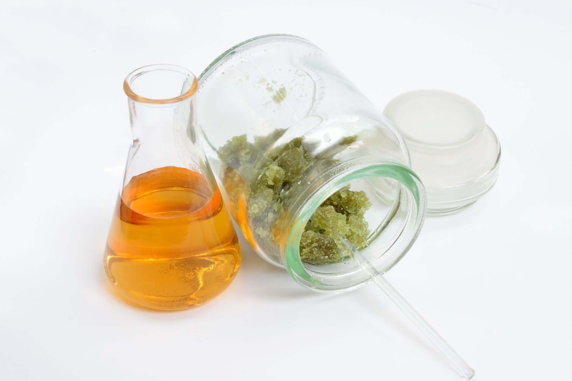 Ferrous sulfate for native plants: amber liquid in flask by spilled green crystals
