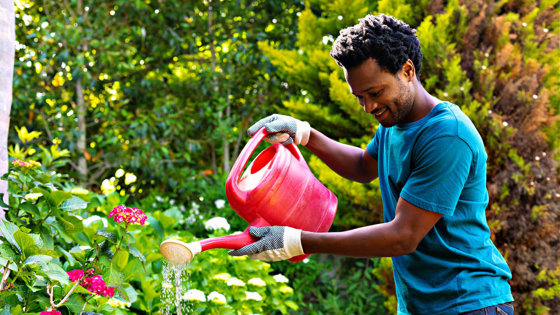 Bright red plastic watering can with wooden spout for efficient irrigation